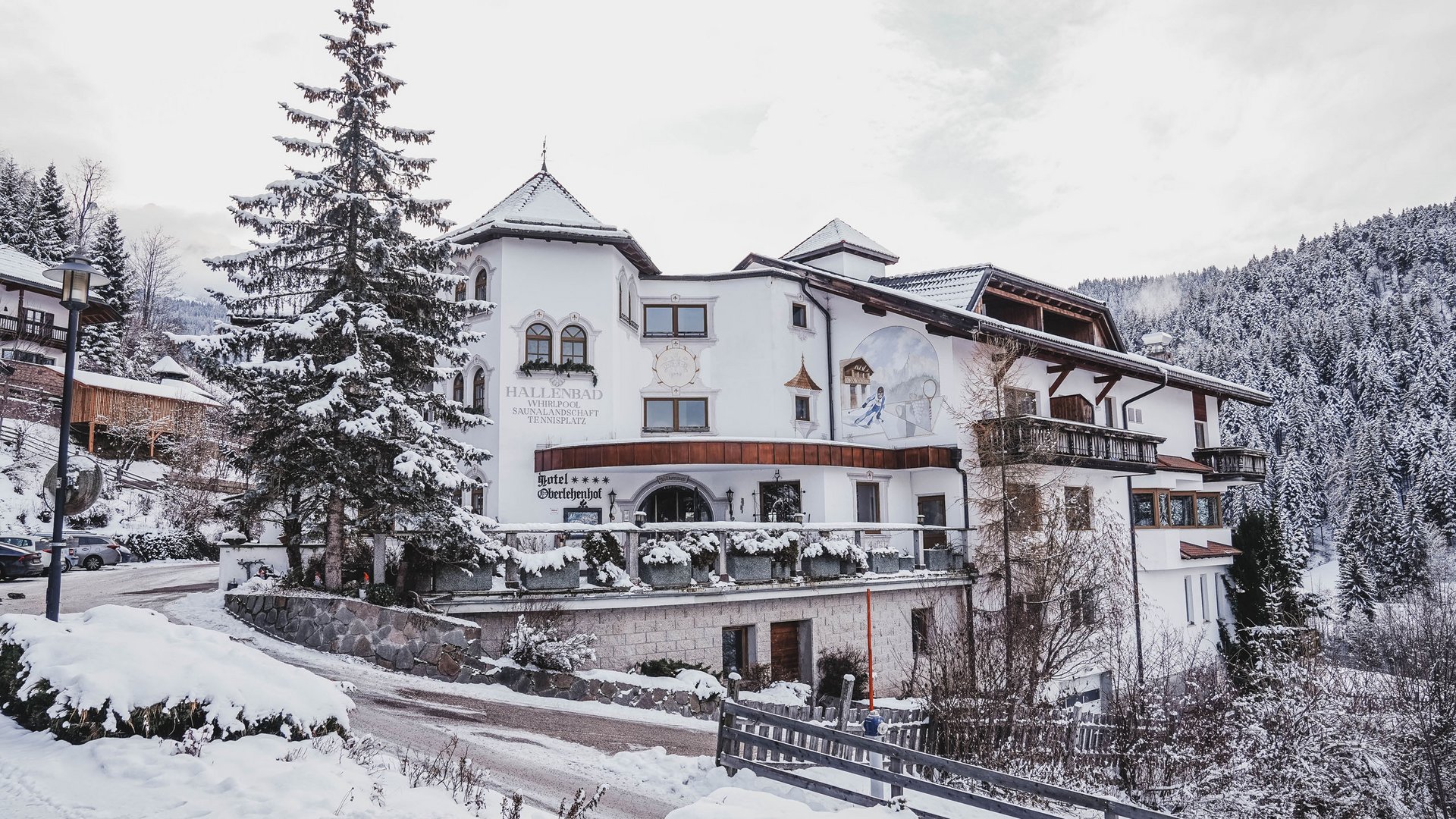 Zu Hause bei uns: das Hotel Oberlehenhof bei Deutschnofen Schneebedecktes Hotel in den Bergen mit Tannenbäumen im Winter